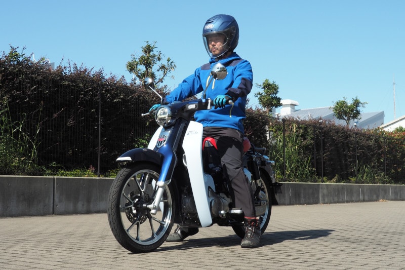 スーパーカブC125に筆者が乗って両足を地面につこうとすると踵が若干浮くが軽量なので怖さはない