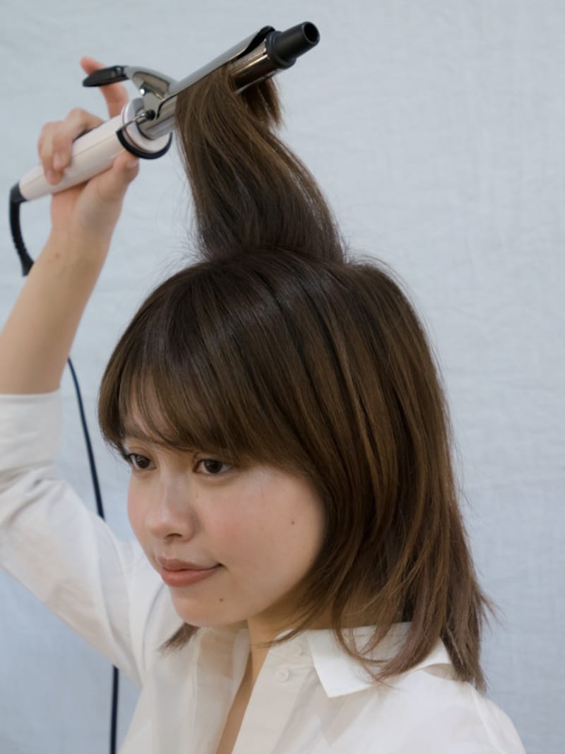 バックのトップの髪を真上に引き出しワンカール巻く