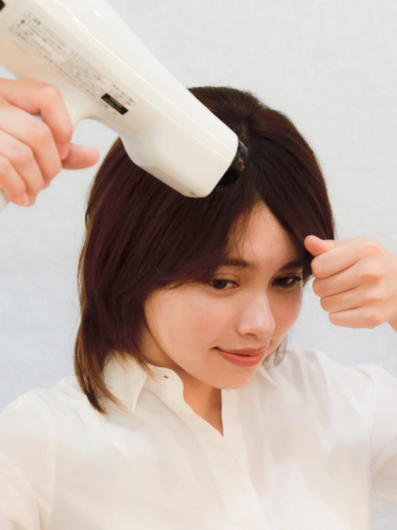 前髪を伸ばすように持つ