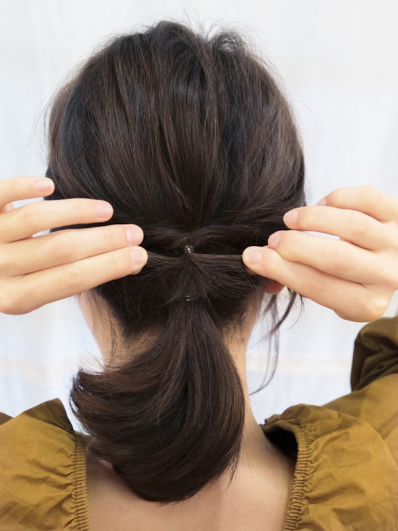 くるりんぱした毛束を二等分し左右に引っ張り、たるみをとる