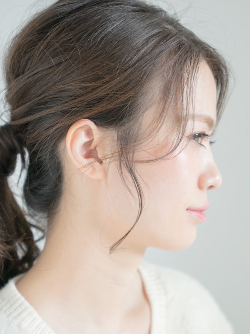 耳前や顔まわりに細い毛束でおくれ毛をつくることで、定番のひとつ結びもこなれた印象に。小顔効果もあり。