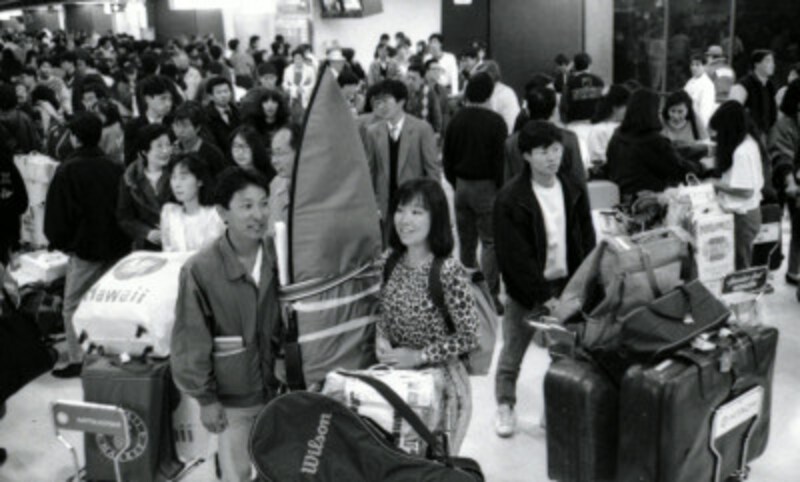 昭和64年、成田空港。年末年始を海外で過ごし帰国した人であふれかえる到着ロビー　写真：読売新聞/アフロ