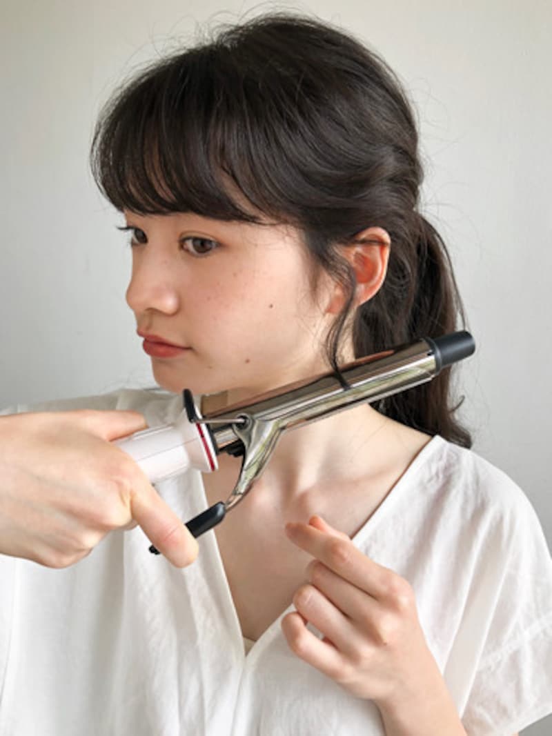 後れ毛をコテで巻いて華やかなひとつ結びに
