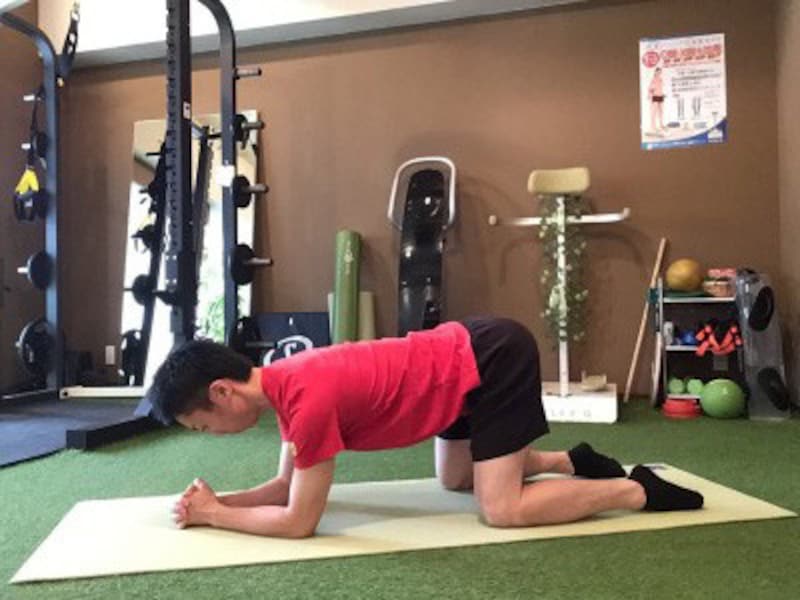 床に肘をつき、両手を組みます