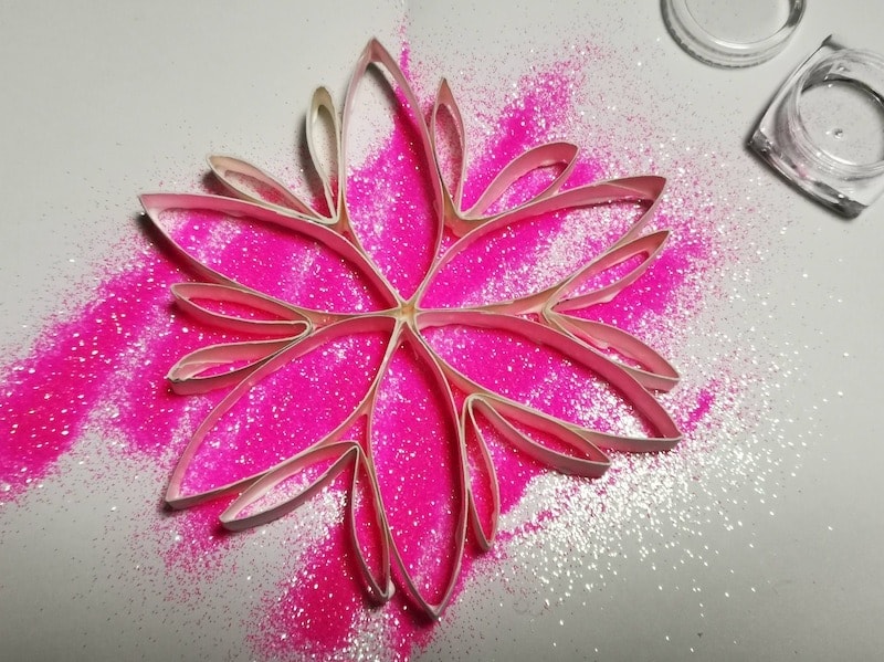 ボンドをつけた面をラメの粉の上に置いて貼付けます