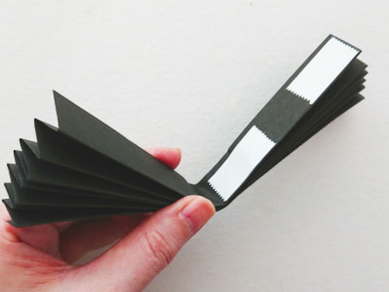 ペーパーファンのハロウィンオーナメントを手作り,扇子を両面テープでとめる