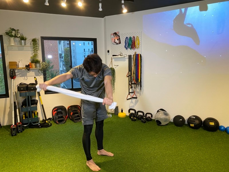 step 2. 背中を丸くしたまま、タオルを体の横に移動させます。