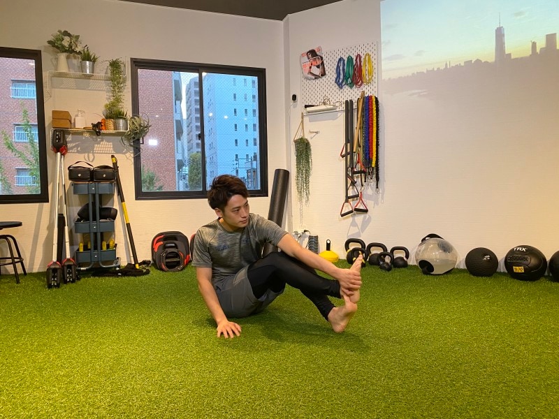 step 2. 反対側の手で内側から足の裏をつかみます。