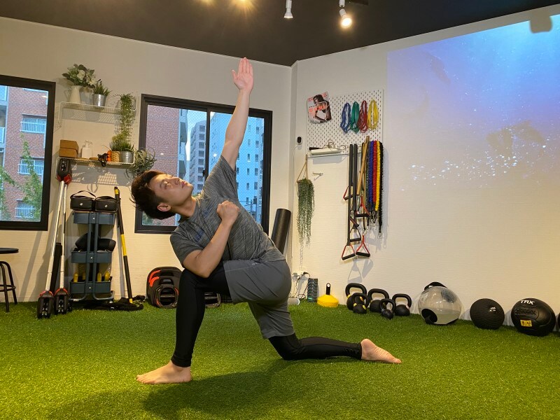 step 2. 膝に肘をついていない方の手を上に挙げ、外側に広げて胸の筋肉を伸ばしましょう。この姿勢で20秒~30秒キープします。