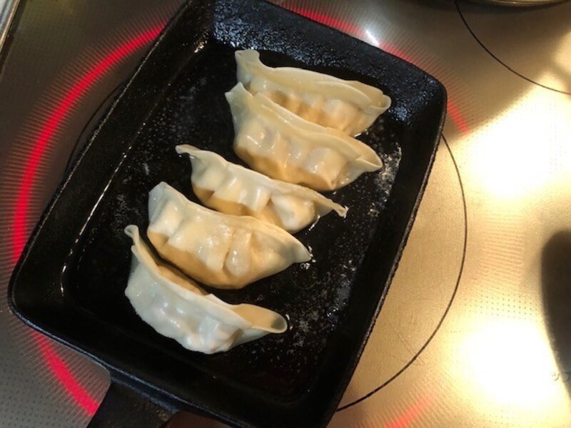 フライパンに油と水を入れ、餃子を並べる