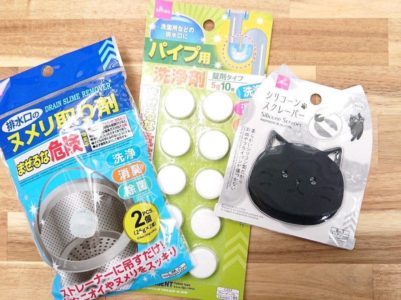ダイソーで揃えた予防アイテム。左から、排水口ストレーナー用ヌメリ取り剤、排水パイプの洗浄剤、食器や調理器具に使うスクレーパー