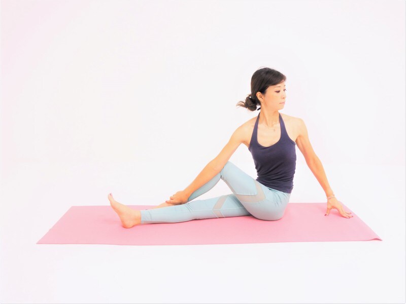 動作3：腕全体で脚を押さえ、左足首をつかみねじりを深めます