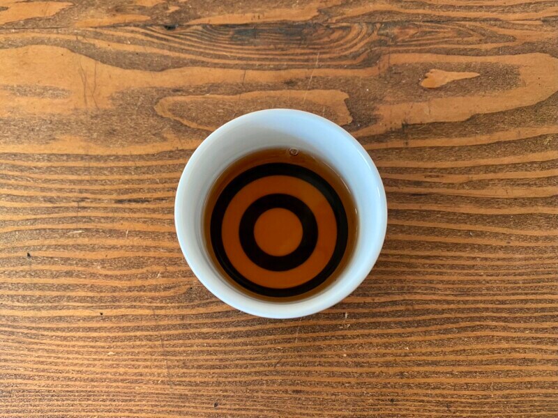 色味を見るためのおちょこに入れてみました。濃い赤茶色です。