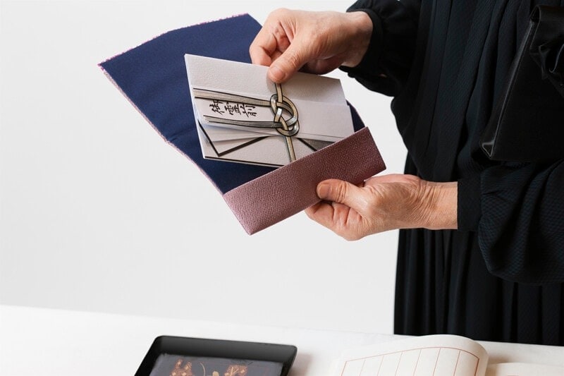 香典は受付直前まで袱紗に入れておき、受付で取り出して渡します。香典を袱紗の上にのせ、相手から見て文字が正面になるよう向きを変え、両手で渡します。