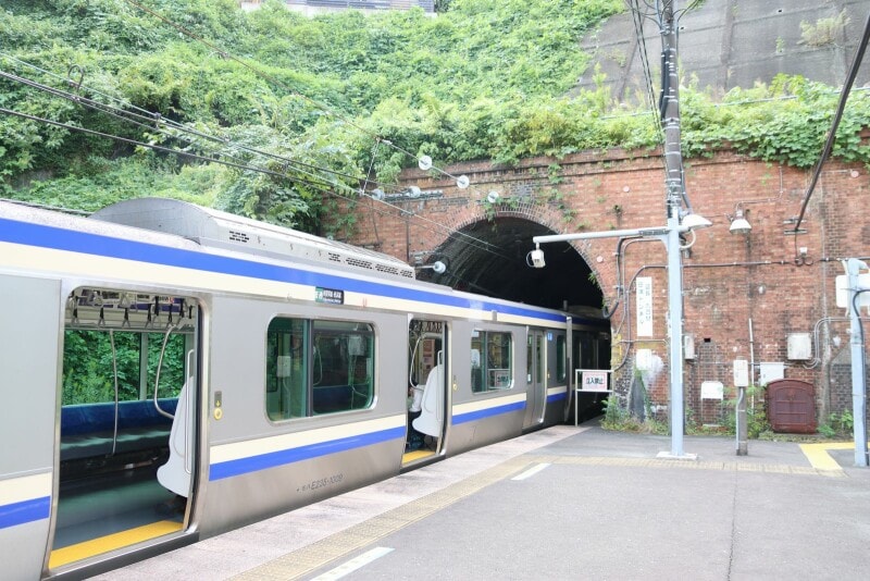 先頭車はトンネルの中、2両目の端のドアは閉じたままだ
