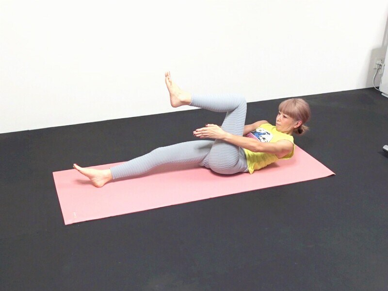 脂肪撃退エクサ6：吐く息と共に上体を起こし、左膝の下で両手をタッチします