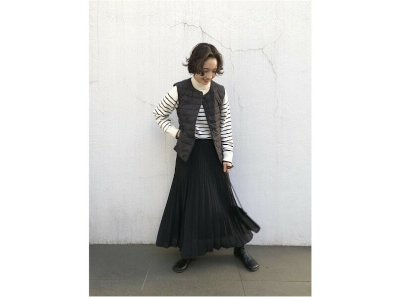 ダウンベストのカジュアル感とスカートのフェミニンさも好相性 出典:StyleHint