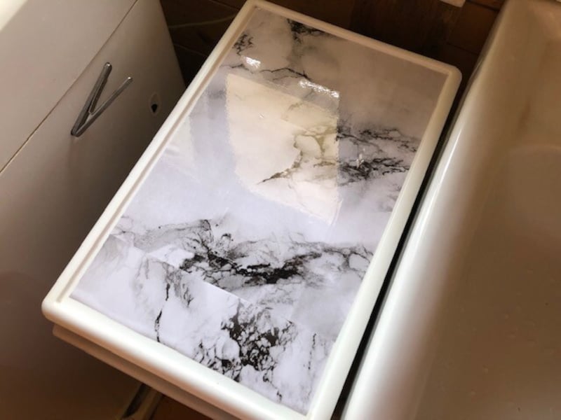 空気を抜きながらダイソーの「大理石柄リメイクシート(ホワイト)」をゆっくり貼る