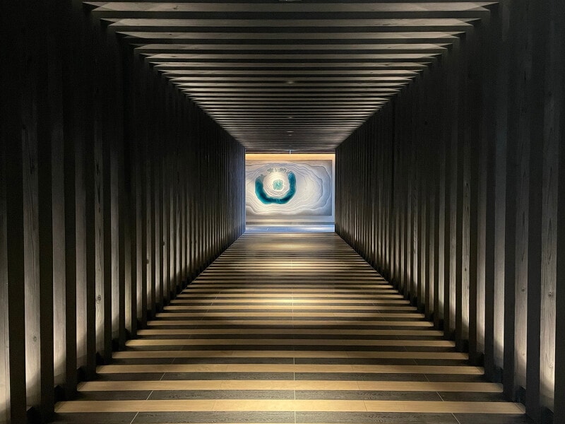 異世界へ誘われるような廊下。つきあたりには八幡平の絶景「ドラゴンアイ」をモチーフにしたアート作品が