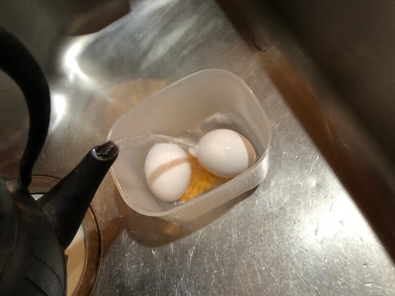 セリアの「温泉たまご器」の本体にたまごを2個入れて、お湯をラインまで入れる。