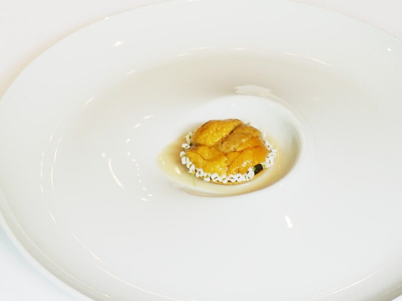 料理の一例。青森の郷土料理をフレンチ風にアレンジ。タルト記事に生ウニとアワビをのせ、貝出汁のソースをかけて提供(※料理は季節で変わります)