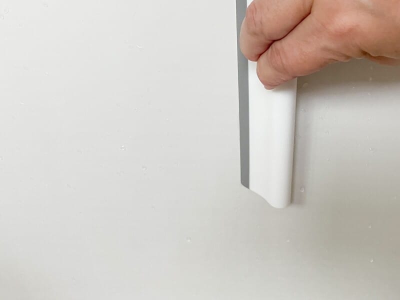 浴室の水滴をスクイージーで取る