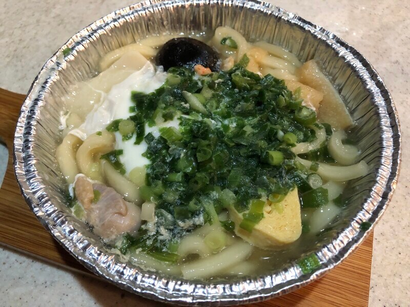 セブンイレブンの「7プレミアム 鍋焼うどん」にきざみねぎを加えて煮込む