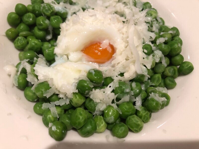 サイゼリヤの「柔らか青豆とペコリーノチーズの温サラダ」には温泉卵も乗っている