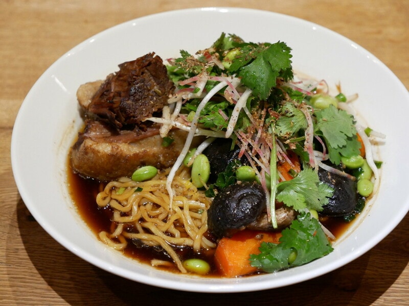 店舗限定メニューのショートリブ ヌードル - コリアンダーとビーツのサラダ、四川スパイス（税込2100円）