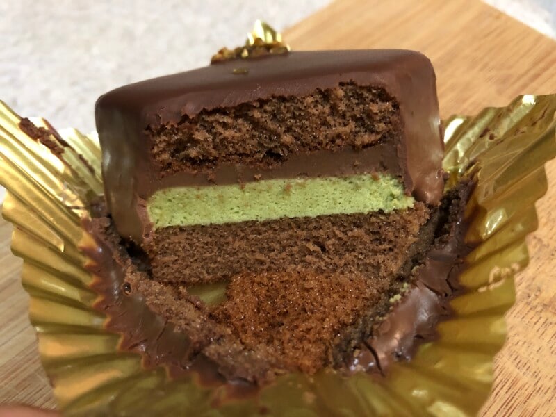 ピスタチオペースト入りのホワイトチョコムースとチョコムース、ココアスポンジが重なる