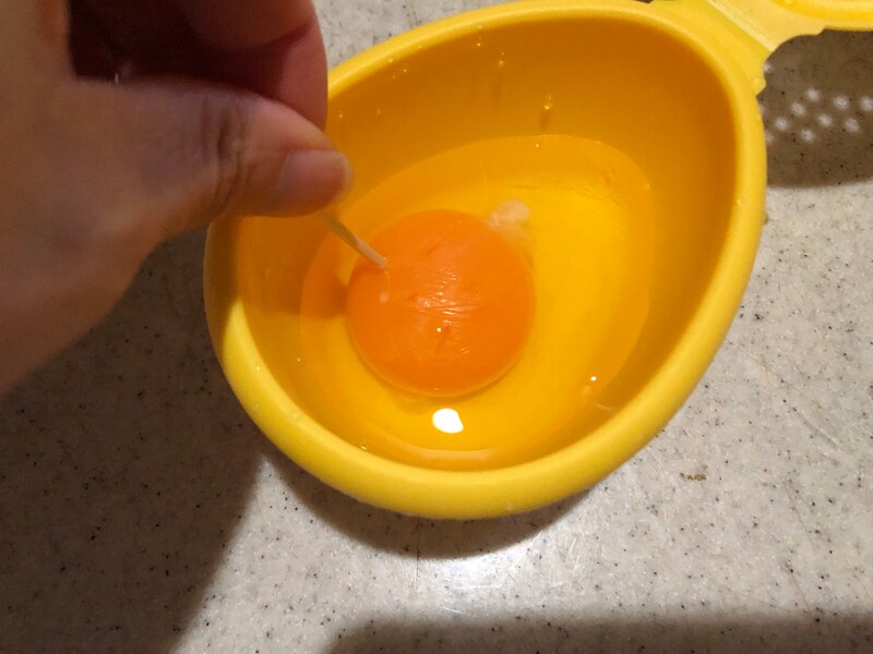 楊枝で卵黄に穴を開ける