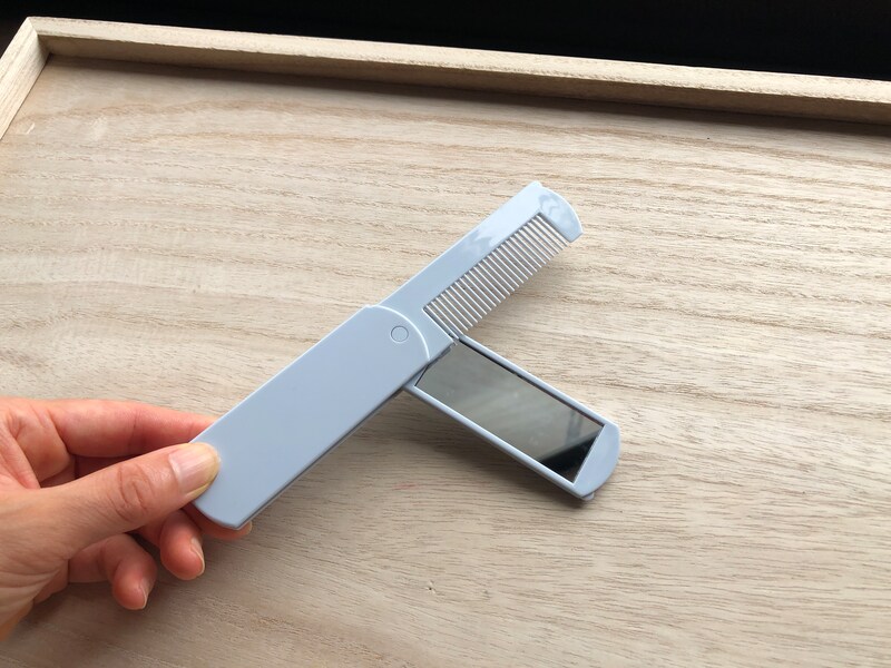 ダイソーの「折込コーム＆ミラー」はくしと鏡が重なるように収納されている