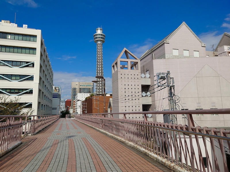 フランス橋（歩道橋）を駆け抜ける誠司の背後には横浜マリンタワーの姿が