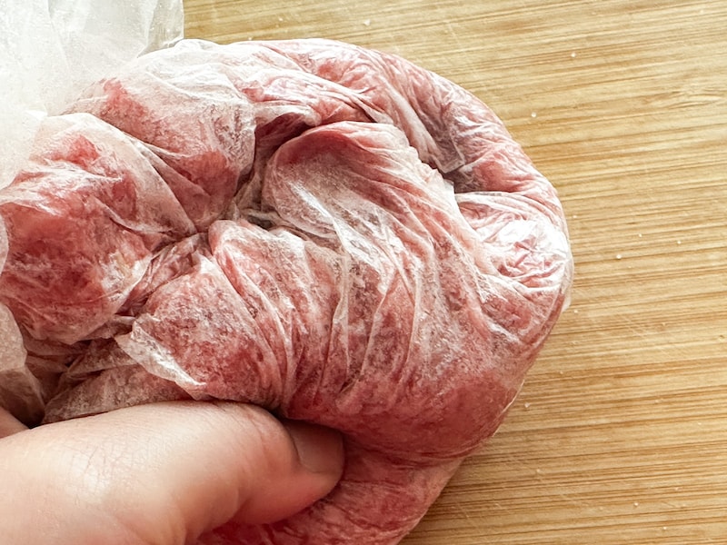 ポリ袋の上から塩を加えた肉をこねる