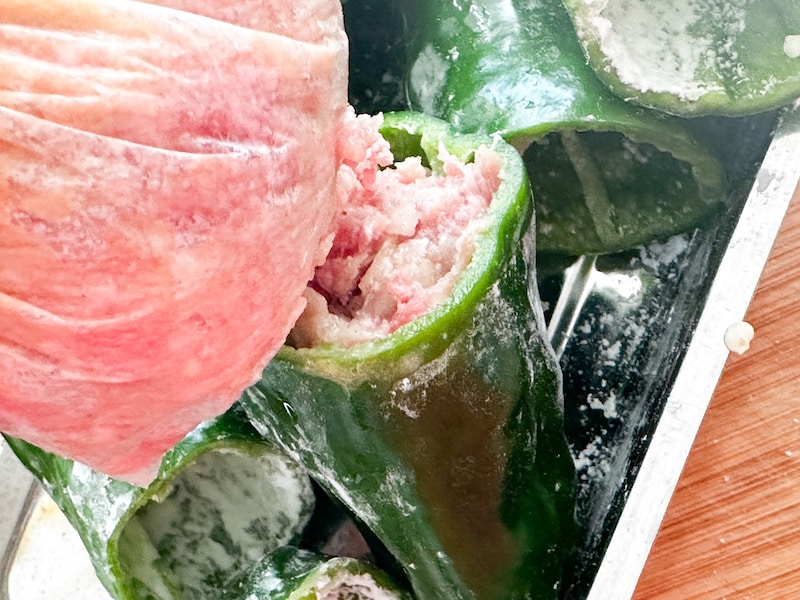 袋の先をカットしてタネをピーマンに詰める