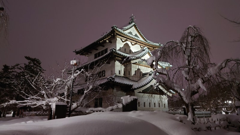 雪景色の弘前城天守閣のライトアップ