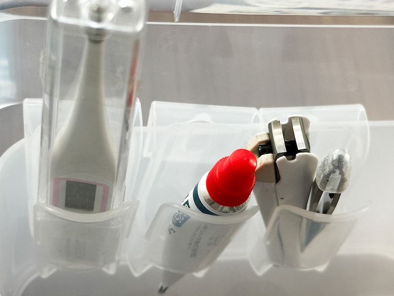 薬味チューブホルダーに体温計、チューブの薬、毛抜と爪切り