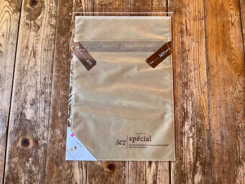 ダイソーの「不織布巾着バッグ（ホテルライク、プリントリボン）」