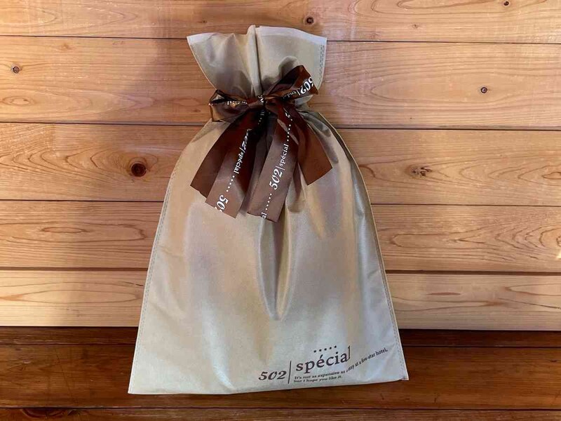 ダイソーの「不織布巾着バッグ（ホテルライク、プリントリボン）」のベースカラーはベージュ