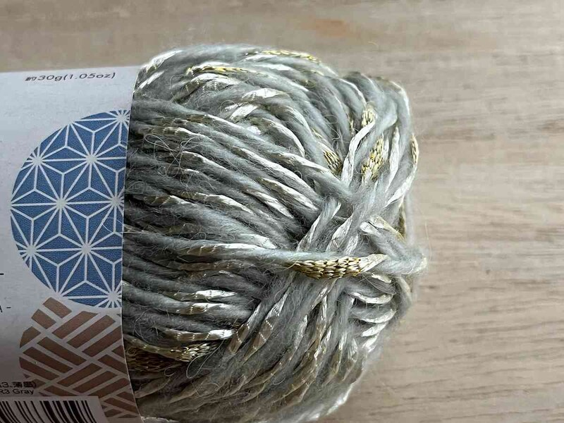 ダイソーの「毛糸（彩り、薄墨）」は薄いグレーに金の模様入り
