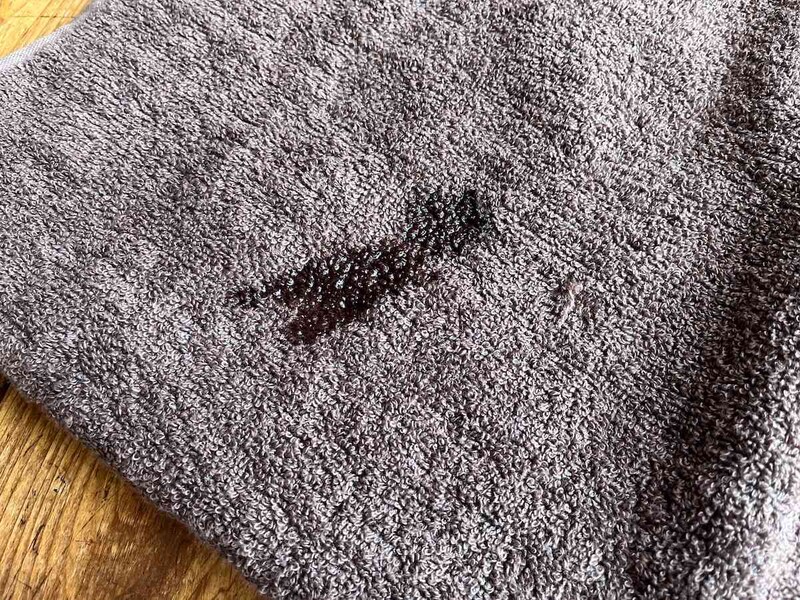 ダイソーの「タオルソムリエ監修 洗濯してもふんわり感長持ちこだわりのバスタオル」に水を垂らすとあっという間に吸収する