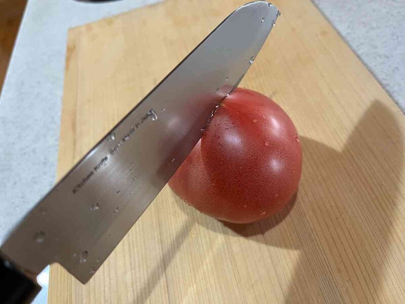 スタンダードプロダクツの「三徳包丁」の刃がトマトに抵抗なく入る
