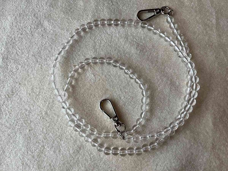 スリーコインズの「ポーチ付き防滴スマホケース」の透明ビーズのようなストラップ