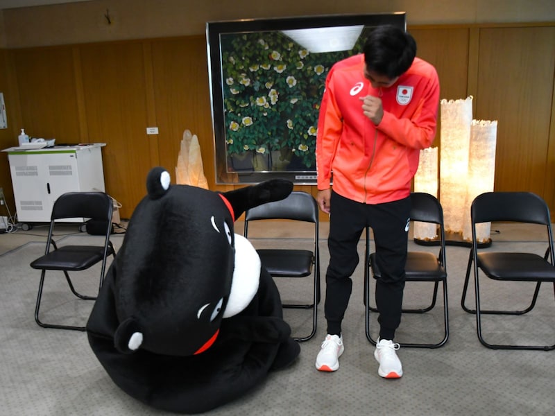 脚の長さに疑問を感じるくまモン（7月19日、熊本市）