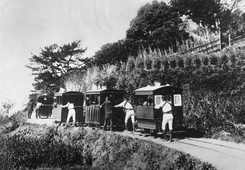 車夫に押され連なって進む豆相人車鉄道の車両(提供:今井写真館)