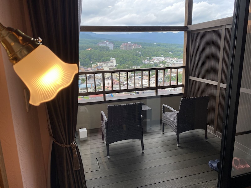 ウッド調のテラスには、眺望を楽しむためのイスと、その右側には客室露天風呂が備わっている