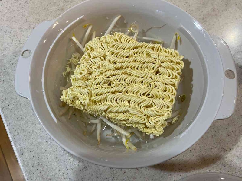 セリアの鍋「電子レンジ調理器 ラーメン」に水と麺、もやしを入れる