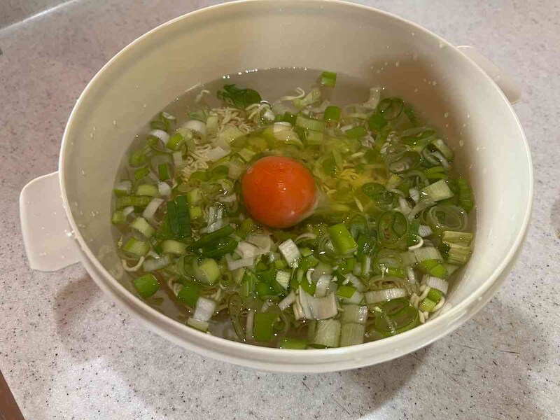 ダイソーの「電子レンジでお手軽ラーメン」の容器に水、即席麺、野菜などを入れる