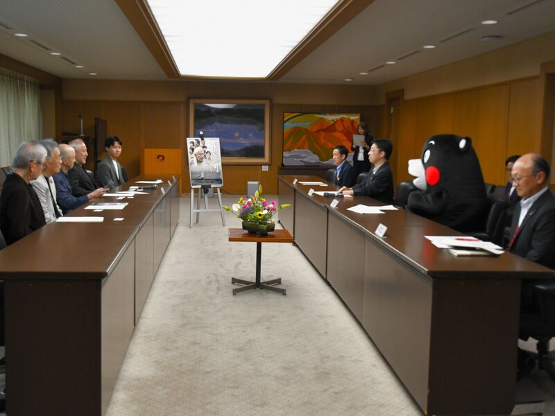 木村知事の隣りでお出迎え＝6月27日、熊本市