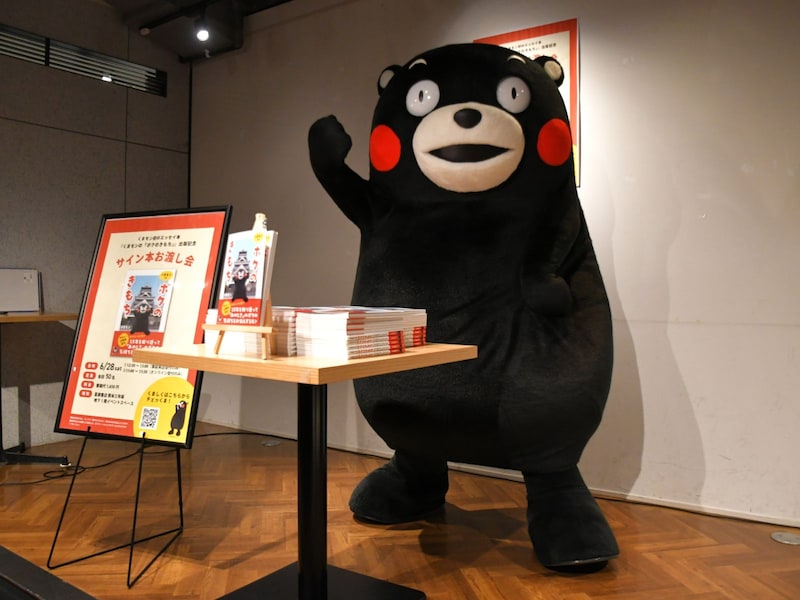 くまモンの「汗つき本」をお渡し＝6月28日、熊本市